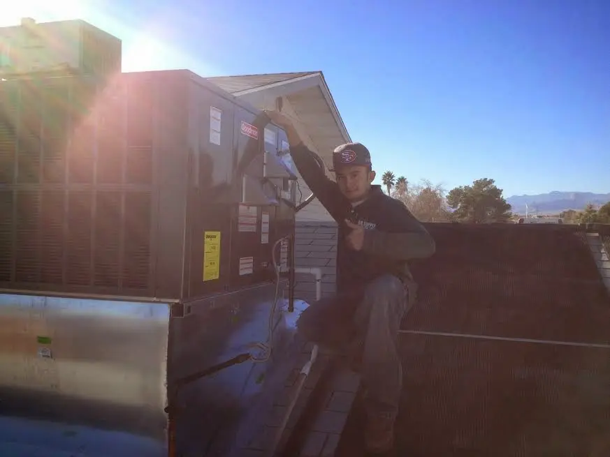 HVAC technician performing Air Duct Repair on a rooftop unit in Zion